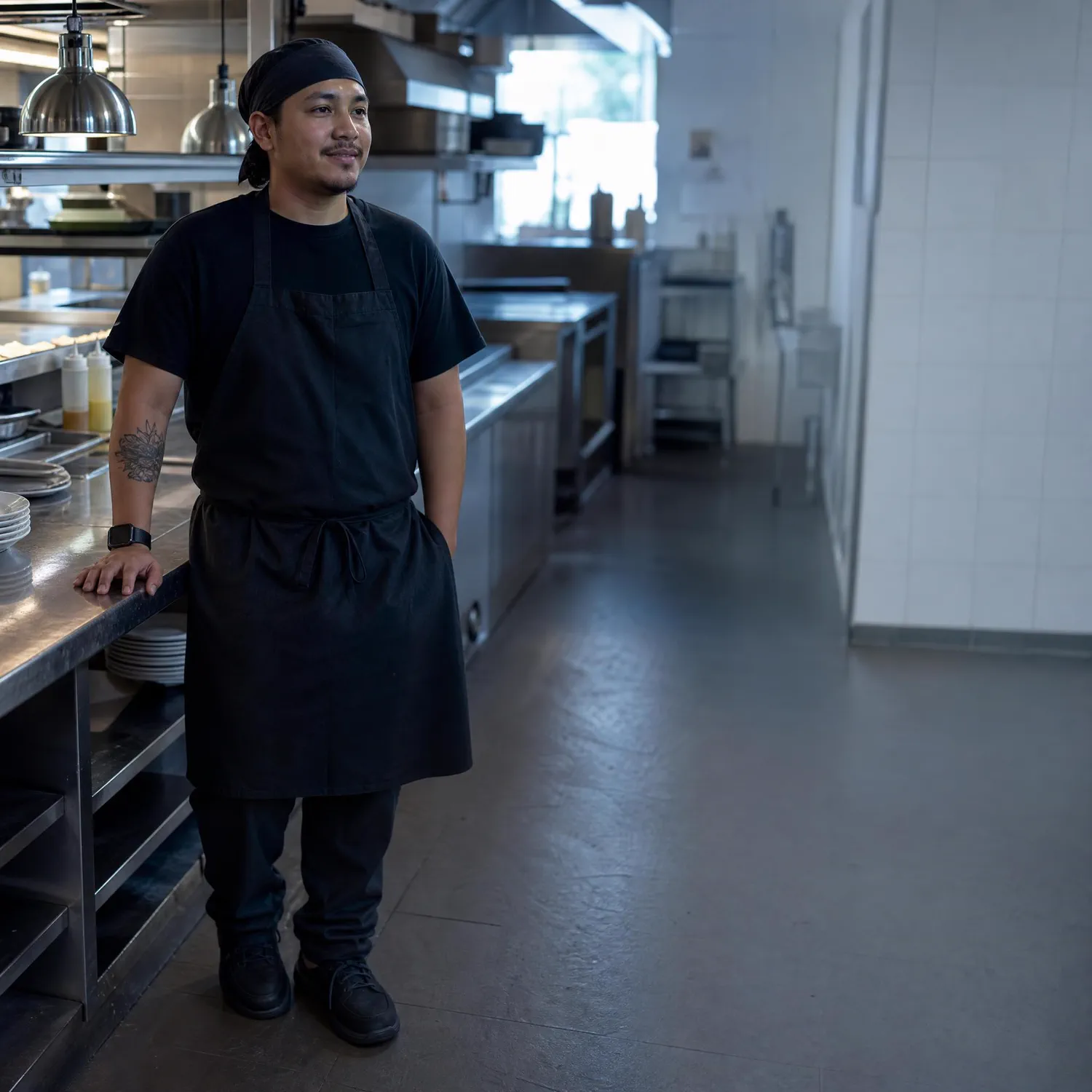 A cook standing in a commercial kitchen