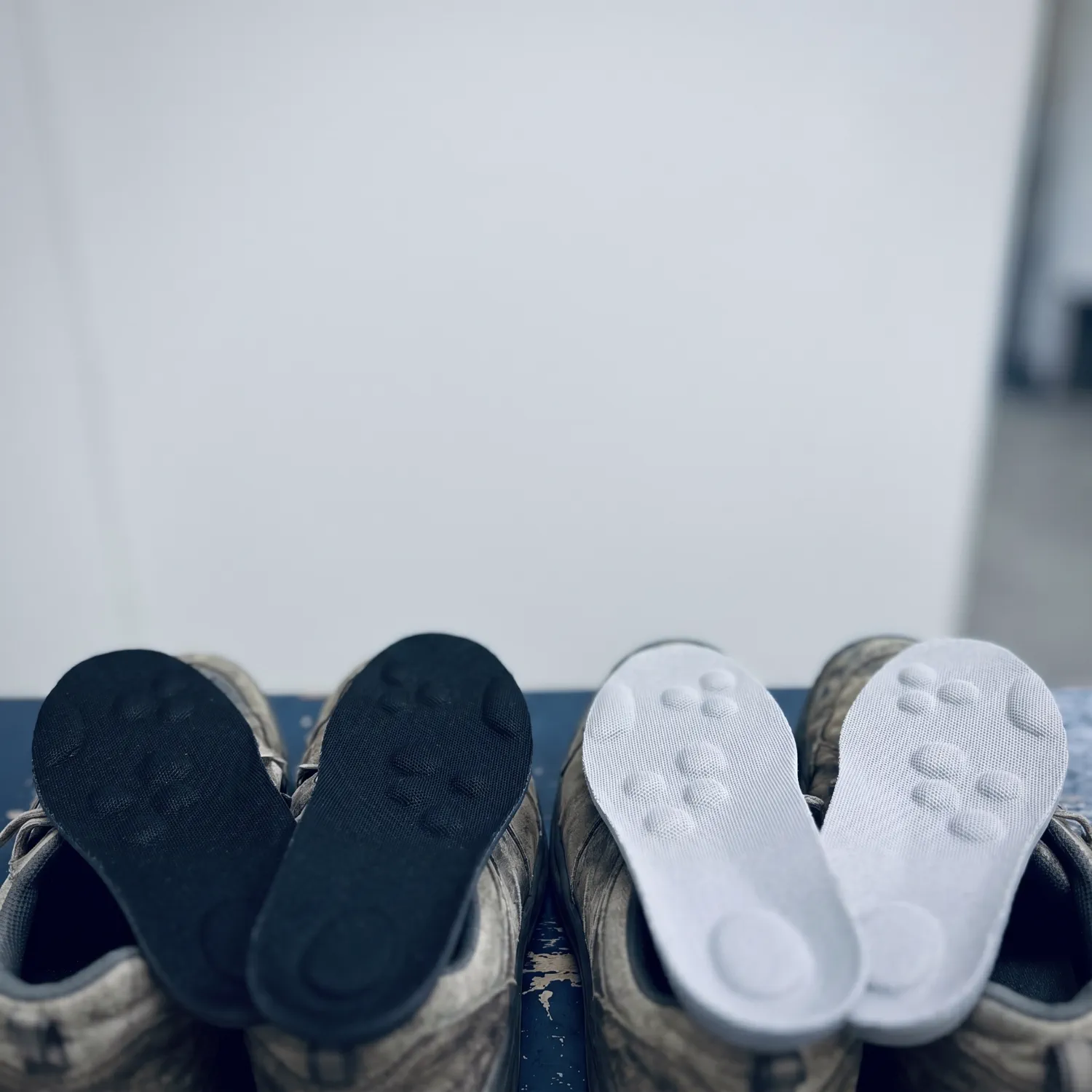 Two pairs of everyday shoes with the insoles dropped in, one black and one Light Gray