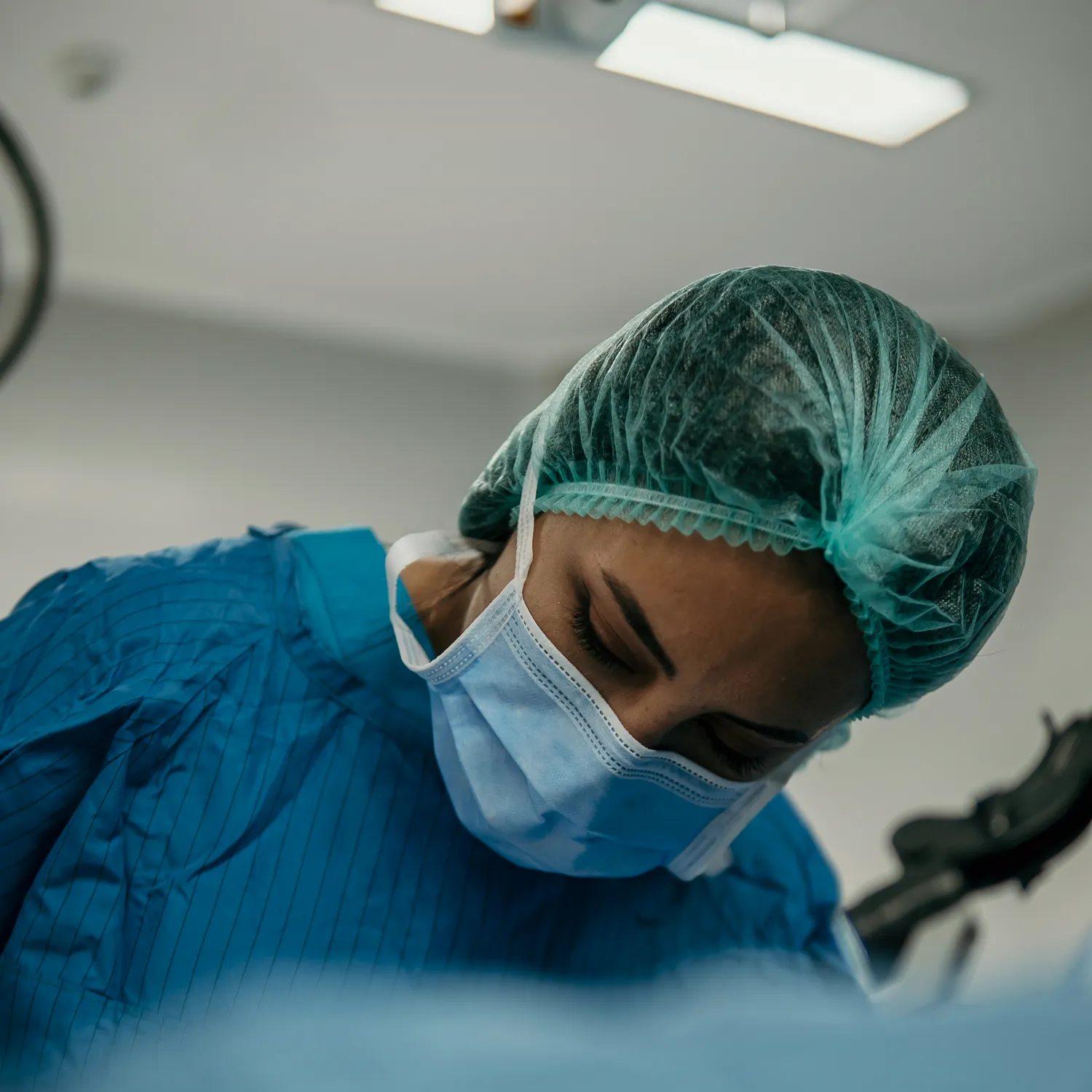A surgeon in scrubs working at an operating table